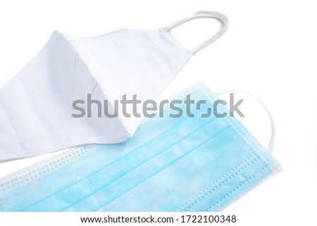 Closeup Medical face mask and white cotton fabric face mask on white background to prevent from Covid19 or Coronavirus, cough, dust and pollution (pm.2.5) Royalty-Free Stock Photo #1722100348