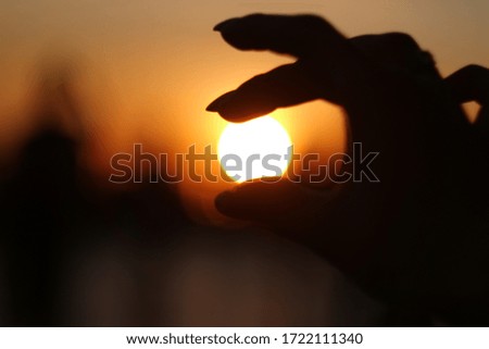 Girl holds the sun on her fingers