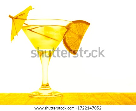 Orange cocktail in a glass isolated on a white background. orange fruit slice. Glass of green juice with umbrellas on white background