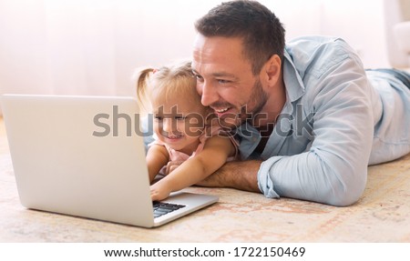 Education Concept. Happy father teaching his little toddler girl how to use personal computer, copy space