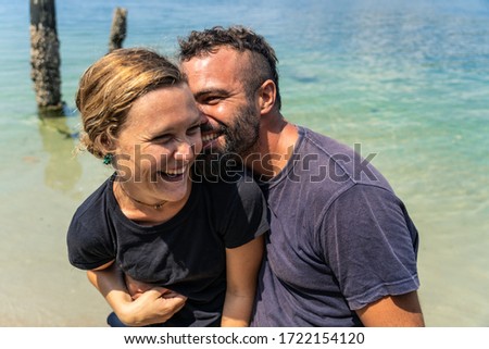 Stock photo of funny couple at the seashore. They are hugging and smiling.