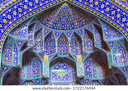 A decorated tile background with religious calligraphic scripts from Persian Islamic Quran at the grand mosque of Isfahan, Iran. Property release is not required for this public place.