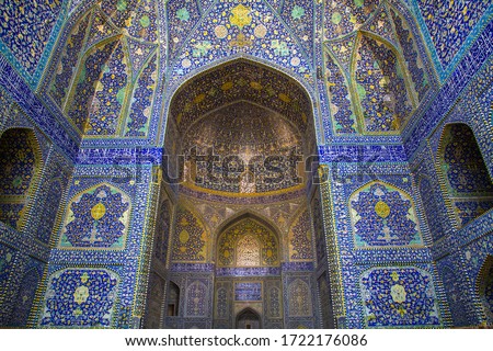 A decorated tile background with religious calligraphic scripts from Persian Islamic Quran at the grand mosque of Isfahan, Iran. Property release is not required for this public place.