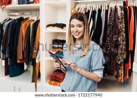 Beautiful female seller working in exclusive boutique or store. Royalty-Free Stock Photo #1722177940