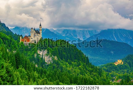 Stunning view on Neuschwanstein and Hohenschwangau castles with mountains covered by clouds in background, Bavaria, Germany