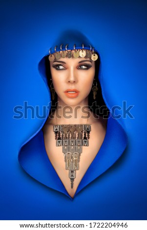 Beautiful arabic style woman with a glamorous makeup, wearing a blue veil and keys as jewels
