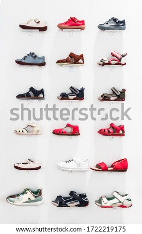Children shoes shop window. Children's sandals and sneakers on a white background