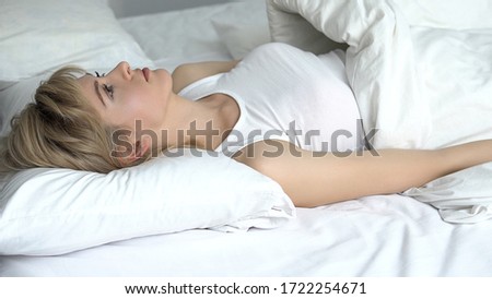 Sad woman has no strength to get out of bed, mood swings, vitamin deficiency Royalty-Free Stock Photo #1722254671