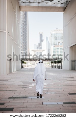 Emirates urban lifestyle in the big city with Arab guy investor checking out the city in gulf country. Photography of Arabian places and building construction.