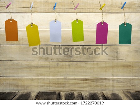Labels hang on a rope with colored clothespins. Colored tags are hung on a rope