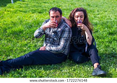 happy couple drinking vine in garden