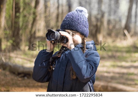 Girl with a camera. Girl photographer in the forest.