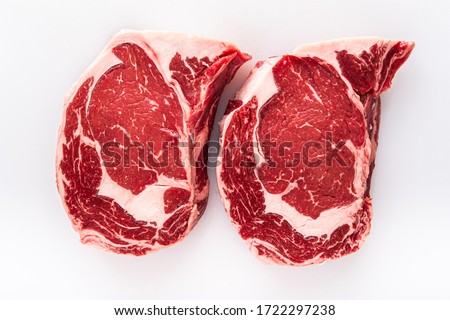 Two freshly cut boneless ribeye steaks on a butchers table Royalty-Free Stock Photo #1722297238