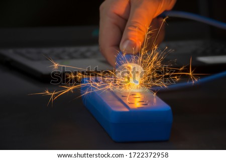 Sparking at the power plug The cause is caused by substandard electrical appliances and cables or excessive use of electricity causing short-circuits, causing danger and causing loss. Royalty-Free Stock Photo #1722372958