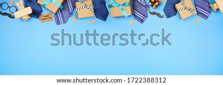 Happy Fathers Day gift tag with long border of ties, gifts and games on a blue banner background. Above view with copy space. Royalty-Free Stock Photo #1722388312
