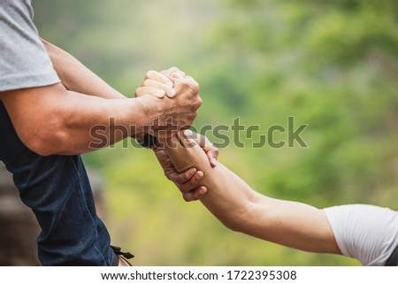 Helping hand outstretched for salvation . Strong hold. Couple hiking help each other in mountains . Two people climbing on mountain and helping. Royalty-Free Stock Photo #1722395308
