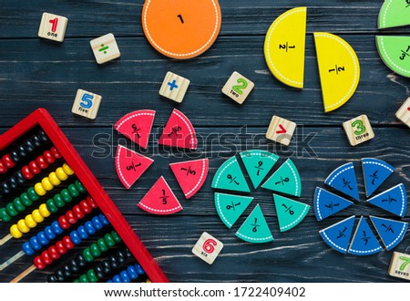 Сolorful math fractions, abacus on dark wooden background or table. Interesting creative funny math games for kids. Education, back to school. Geometry and mathematics materials. Abstract thinking 
