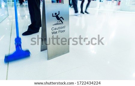 Cleaning in progress with wet floor caution sign besides.