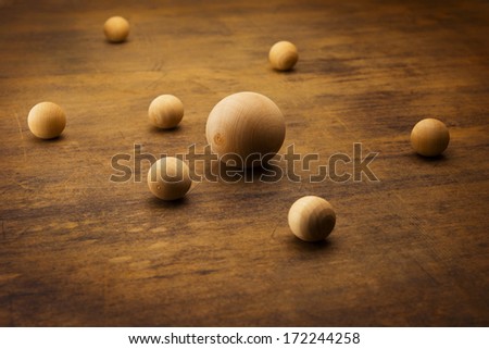 Wooden spheres on a grungy old desk, representing a planetary or atomic particle formation. 