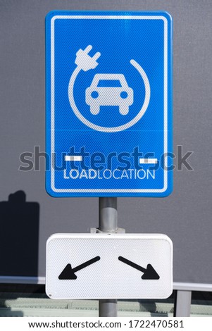 electrical charging station sign conveniently located next to a public parking lot