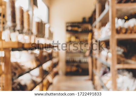 Blurred background of interior in zero waste shop. Customers buying dry goods and bulk products in plastic free grocery store. Conscious shopping, sustainable small businesses, minimalist lifestyle. Royalty-Free Stock Photo #1722491833