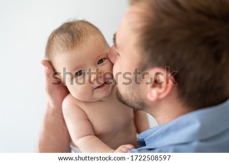 Young father holding his newborn baby daughter