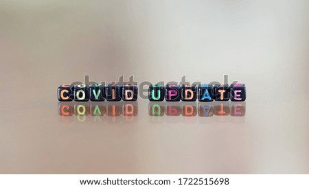 Alphabet colorful black block of word "COVID UPDATE" closeup blur background