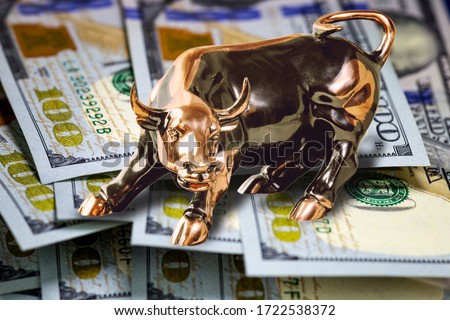 Concept of usa cash money.  Copper bull standing on hundred us dollar bills. Macro image.