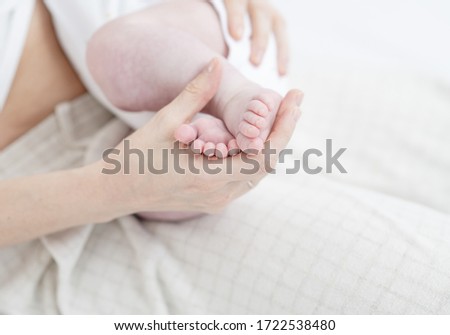 Selective focus leg the sleeping baby in the hand of mother close-up