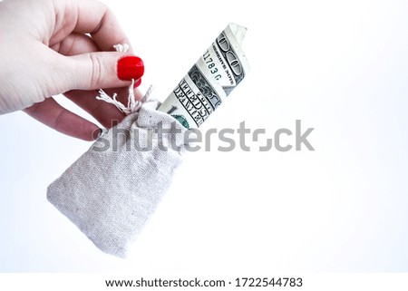 Businessman hand with a bag full of dollar banknotes on white, copy space for text, hand holding curencies dollars, 100 bill of us curency