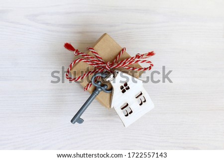 house with key and gift top view on a light wooden surface. advantageous offer in real estate
