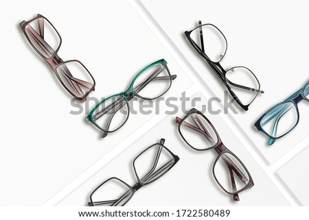 Composition of many different classic style glasses on white square stands. Studio photo.