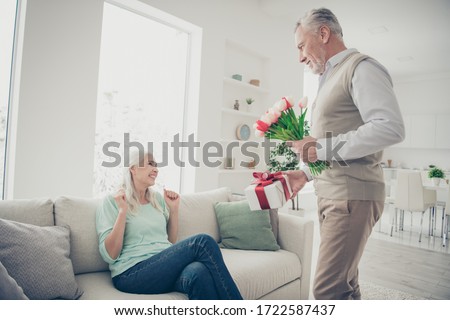 Profile photo of two adorable aged people anniversary holiday surprise big red tulips bunch and giftbox