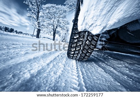 Car tires on winter road Royalty-Free Stock Photo #172259177