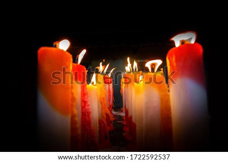 Numerous colorful candles are flaming in the temple.