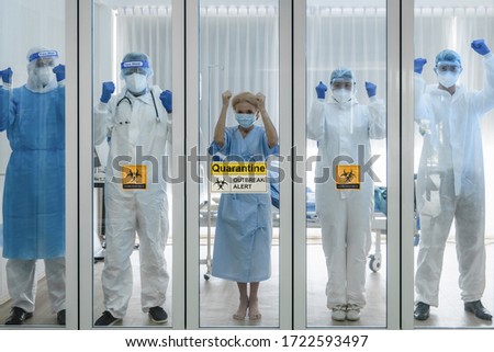 coronavirus covid-19 infected caucasian senior patient with doctor and medical team standing line up in quarantine room to show their strong will to fight coronavirus covid-19 desease