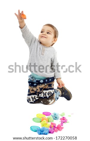 Happy caucasian toddler boy playing with clay dough, isolated on white background