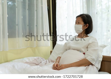 portrait picture of senior asian woman wearing face mask after getting sick from covid-19 or coronavirus infection. medical, new normal, social distancing concept