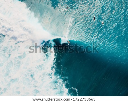 Blue wave with foam in ocean. Aerial view of barrel waves. Top view
