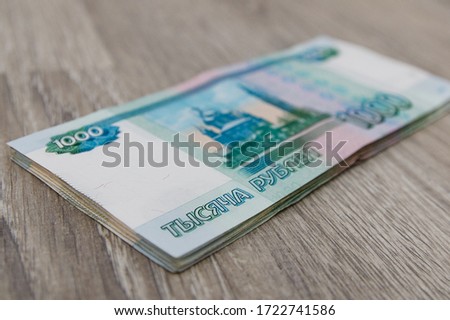 Finance, rental and new home concept - bundle of money Russian Banknotes thousand rubles on wooden table