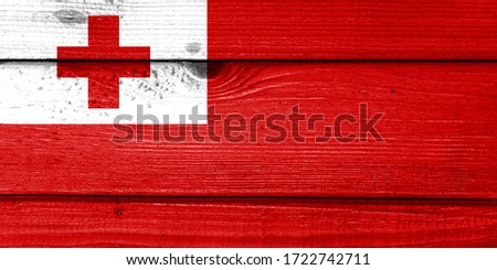 Tonga flag painted on old wood plank background. Brushed natural light knotted wooden board texture. Wooden texture background flag of Tonga