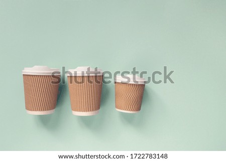 Paper cups of coffee to go on pastel background. Flat lay.