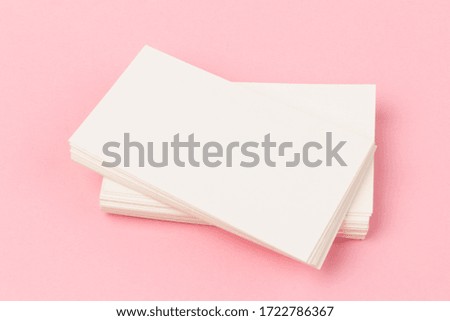 stacks of white blank business cards on pink  background in close-up