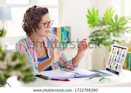 Online remote learning. Teacher with computer having video conference chat with student and class group. Teaching and learning from home. Homeschooling during quarantine and coronavirus outbreak. Royalty-Free Stock Photo #1722788380