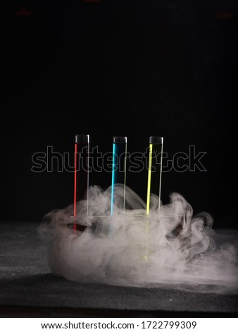 Colorful shot drinks in glass tubes and surrounded by steam. Dark background, atmospheric bar image Royalty-Free Stock Photo #1722799309