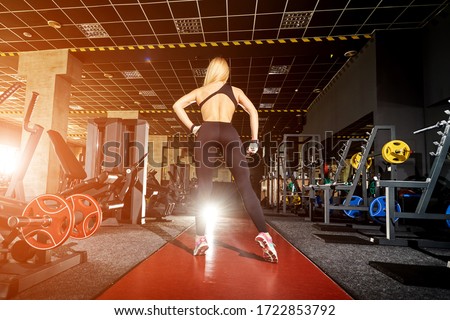 Woman with perfect sport body posing for fitness ideal in gym.