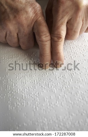 Old woman' s hands, reading a book with braille language