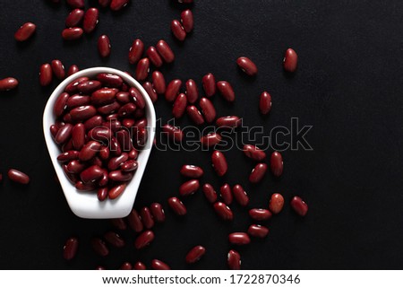 red beans in a white cup on a black background. copy space. top view.Vegetarian food. Unprepared.