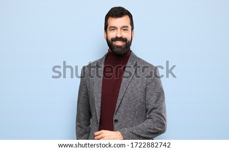 Happy Handsome man with beard walking over isolated blue background Royalty-Free Stock Photo #1722882742