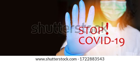 The concept of protection against bacteria and viruses. Woman wearing surgical face mask and gloves,protective against influenza sickness viruses and disease  showing stop sign with her hand .
